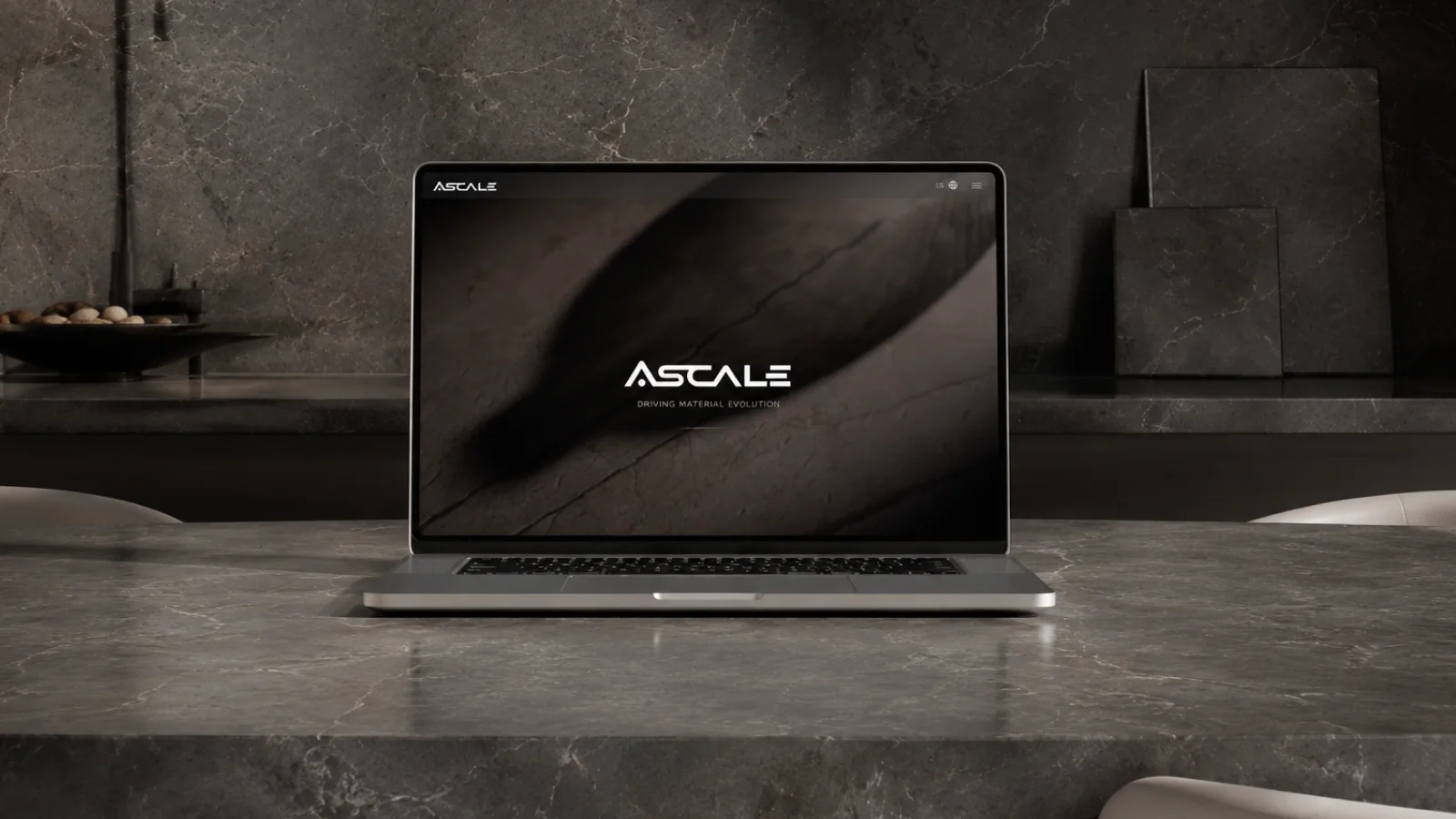 Portátil sobre una encimera de mármol gris oscuro en el showroom de Ascale, con la portada de la web de Ascale abierta en la pantalla.